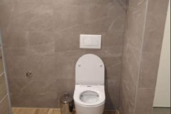 Moderna klozetska šolja u renoviranom kupatilu sa smeđim pločicama